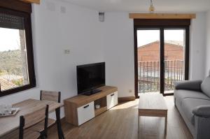 a living room with a couch and a tv at La Costurera in Navatalgordo