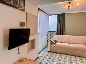 a living room with a couch and a flat screen tv at Vedi Napoli in Vacanza in Naples