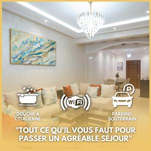 un soggiorno con un divano e un lampadario di Appartement Cosy à Malabata Plage - Bord de mer et Gare TGV 3' à pied, Tanger City Mall à 2' à pied - Parking, WIFI, IPTV, AC a Tangeri