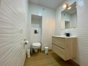 La salle de bains blanche est pourvue de toilettes et d'un lavabo. dans l'établissement Pinzon Studios & Penthouse, à Alicante