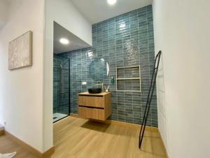 La salle de bains est pourvue d'un lavabo et d'une douche avec du carrelage vert. dans l'établissement Pinzon Studios & Penthouse, à Alicante