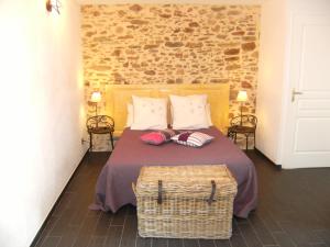 a bedroom with a bed with a basket on it at Domaine du Fief aux Dames in Monnières