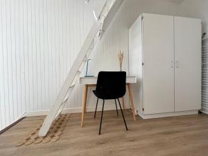 Cette chambre comprend un bureau avec une chaise et un escalier. dans l'établissement Bénodet Centre - Triplex - 4 pers, à Bénodet