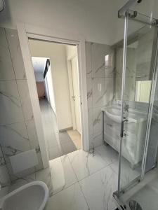 a white bathroom with a sink and a shower at Appartamento nel cuore di Forlì in Forlì