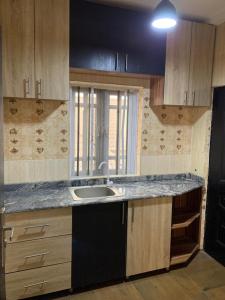 eine leere Küche mit einem Waschbecken und einem Fenster in der Unterkunft Garden View Holiday Cottage in Abakaliki