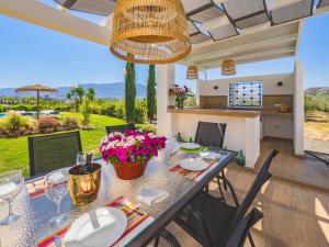 a dining room with a table with flowers on it at Cubo's Casa Rural El Oasis De Don Pedro in Villafranco de Guadalhorce