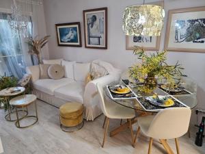sala de estar con mesa y sofá blanco en Apto La Mimosa - Salou, en Salou