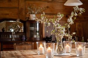 a vase of flowers and candles on a table at Butterfly Factory in Jonkowo