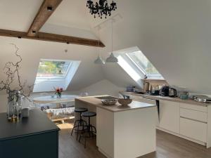 a kitchen with white cabinets and a table with chairs at Kerschbaumer.Apartments in Waidhofen an der Ybbs