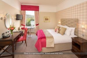 a hotel room with a bed and a desk and a desk at The Belsfield Hotel in Bowness-on-Windermere