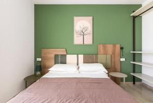 - une chambre dotée d'un lit avec un mur vert dans l'établissement B&B Appia, à Brindisi