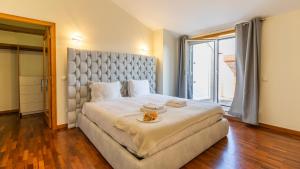 a bedroom with a large bed and a large window at São Felix Seaview Retreat by LovelyStay in São Félix da Marinha
