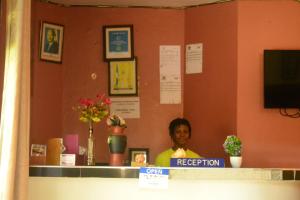 Eine Frau, die hinter einem Tresen in einem Laden steht. in der Unterkunft Lakeshore Bed and Breakfast in Entebbe