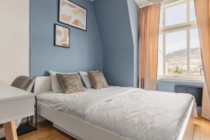 - une chambre bleue avec un lit et une fenêtre dans l'établissement 2-Story Top Floor I 3x Work Space I Shared Garden, à Bergen