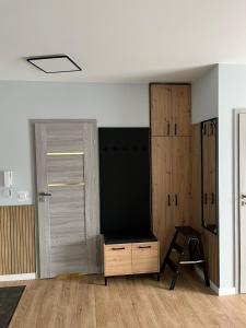 a room with a closet and a door and a stool at Apartament AMBRA II in Jantar