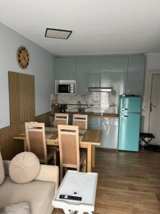 a kitchen with a table and a blue refrigerator at Apartament AMBRA II in Jantar