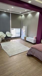 - une chambre avec un lit et un mur violet dans l'établissement Luxury house with swimming pool, à Ben Arous
