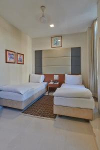 孟買的住宿－Elphinstone Hotel，一间卧室配有两张床和一张桌子