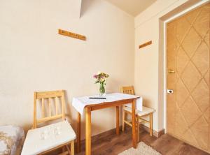 a dining room table with a vase of flowers on it at Apartamenty nad Młynówką in Chochołów