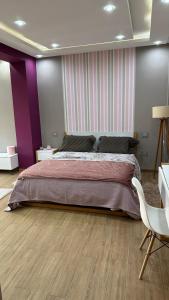 1 dormitorio con cama grande y pared morada en Luxury house with swimming pool, en Ben Arous