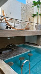 una piscina con sillas y una hamaca en un edificio en Luxury house with swimming pool, en Ben Arous