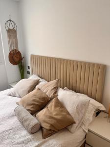 Una cama con sábanas blancas y almohadas. en 269 Main Street 3 bedrooms Gem, en Gibraltar