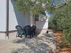 dwa krzesła i stół pod drzewem w obiekcie Apartment in Punat with Terrace, Air conditioning, Wi-Fi, Washing machine (3829-2) w mieście Punat