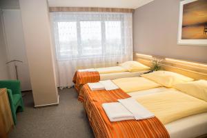 Łóżko lub łóżka w pokoju w obiekcie Hotel Panon
