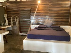 um quarto com uma cama e uma parede de madeira em Upali Beach Surf Resort & Café em Arugam Bay