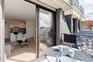 een balkon met een tafel en uitzicht op de stad bij Le Bagatelle C.L.S Deauville in Deauville