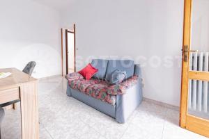 un sofá gris con almohadas rojas en una habitación en Lucy's Flat - Melendugno en Melendugno