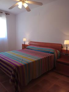 una camera con un letto con una coperta a righe di Atico Canet a Canet de Berenguer