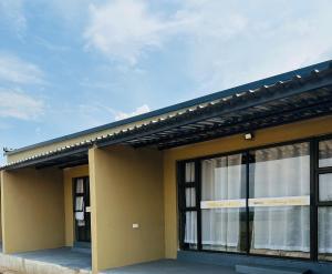 ein gelbes Gebäude mit Fenstern und einem Dach in der Unterkunft Riverfront Resort and Camping in Shakawe