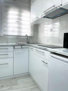 a white kitchen with white cabinets and a sink at Apartment in the center of Athens in Athens
