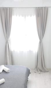 a white bedroom with a bed and a window at Apartment in the center of Athens in Athens