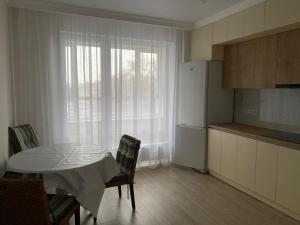eine Küche mit einem Tisch und eine Küche mit einem Fenster in der Unterkunft ala park in Almaty