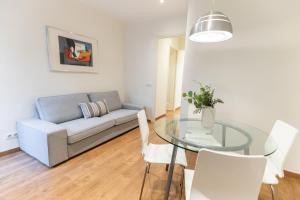 a living room with a glass table and a couch at Atica Apartments - by Weflating in Barcelona