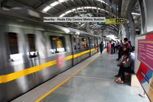 een metro in een metrostation waar mensen wachten bij OYO Krishna residency in Gurgaon