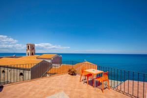 a balcony with a table and chairs and the ocean at Dolce Vita Rooms and Apartments in Cefalù