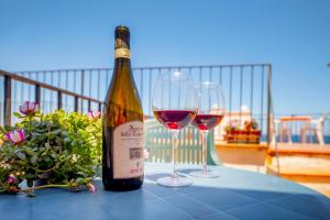 a bottle of wine and two glasses on a table at Dolce Vita Rooms and Apartments in Cefalù +65 photos