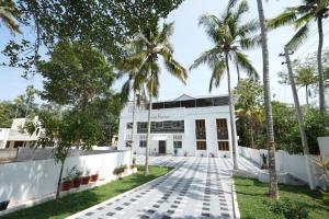 瓦卡拉的住宿－VILLA MANTRAA，一座白色的建筑,前面有棕榈树