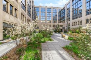 an office building with a garden in front of it at Limehome Munich Fritz-Erler Str in Munich