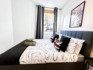 a bedroom with a bed with pillows and a window at Elegant 1BR Flat in the Heart of Hackney in London