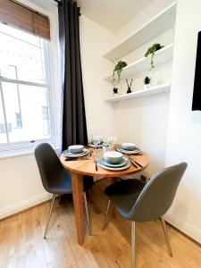 a dining room with a wooden table and chairs at Elegant 1BR Flat in the Heart of Hackney in London