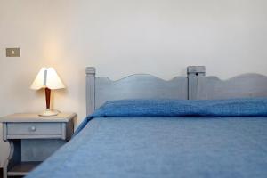 een slaapkamer met een blauw bed en een lamp op een tafel bij E6-2 bilocale Borgo della Rovere in San Bartolomeo al Mare