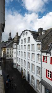 Ein weißes Gebäude mit Leuten, die davor laufen. in der Unterkunft Hotel Royal in Monschau