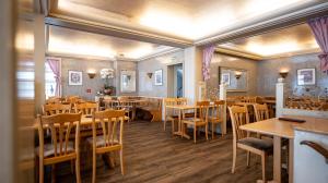 a dining room with wooden tables and chairs at Hotel Royal in Monschau