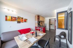 een woonkamer met een tafel en een bank bij Résidence Kocoon Les Karellis - Skipass inclus in Montricher-Albanne