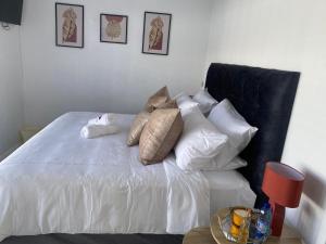 a bedroom with a white bed with pillows on it at 32 On Gill Road Self Catering in Cape Town