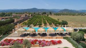 a resort with a pool and a garden with flowers at Cas Metge Matas in Santa Maria del Camí